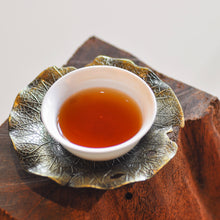 Load image into Gallery viewer, a cup of liu bao tea on a wood