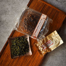 Load image into Gallery viewer, a tray of white lotus mooncakes and oolong tea leaves
